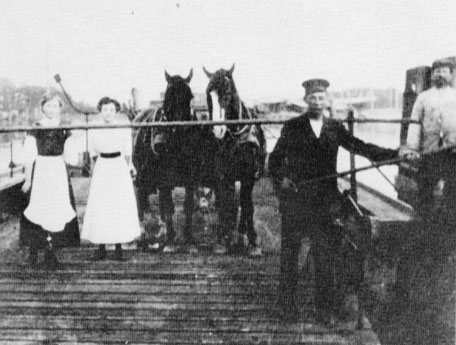 Fährmann Peter Wendelborn, Vater des Firmengründers, beim Festmachen des Fährprahms auf der Travemünder Seite © Presseabteilung von „Lübeck-Verkehr“